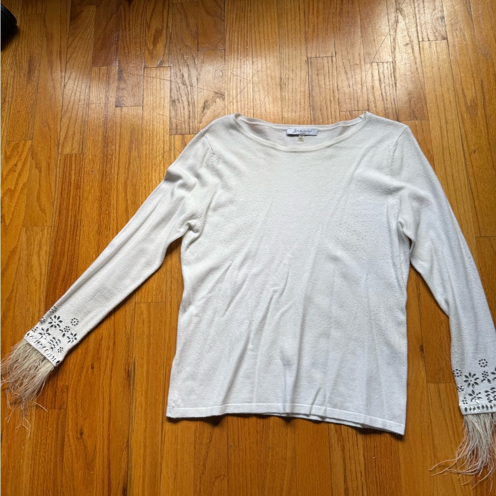 White sweater with embellishments and feathers